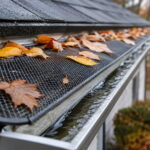 Types of gutter guards shown with a mesh guard blocking autumn leaves while water flows freely underneath into the gutter